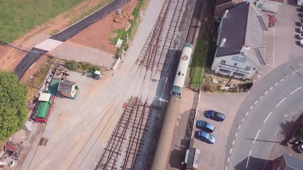 Forward tracking aerial shot over a diesel engine with a radiator fan driving out of a built up coun