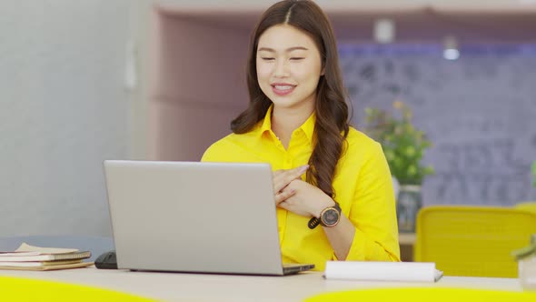 young asian business woman wears yellow shirt meeting online video conference call