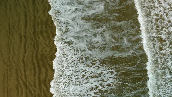 Aerial view of incoming waves rolling over the beach at the 90 mile beach, new Zealand