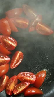 Preparation Fried Eggs with Tomato in Frying Pan for Breakfast on Stove on Domestic Kitchen