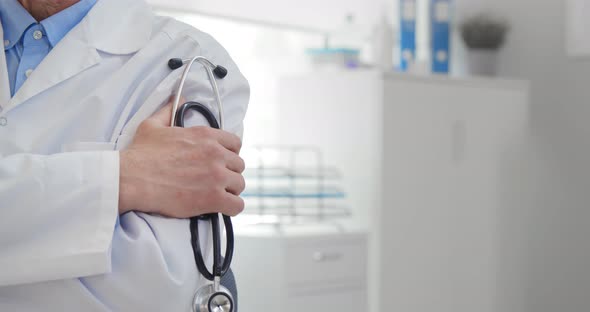 Cropped Shot of Male Therapist with Arms Crossed Holding Stethoscope