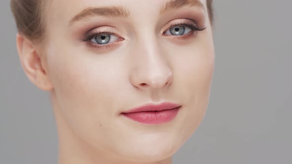 Studio portrait of young, beautiful and natural woman over grey background.