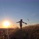 a woman in a suit runs across a field at sunset - VideoHive Item for Sale