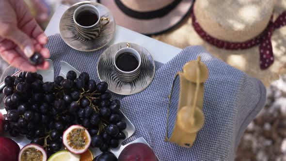 Top View Tray with Delicious Exotic Fruits and Female Hand Taking Grape in Slow Motion Leaving