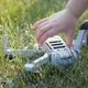 A Child's Hand Picks Up a Fallen Drone From a Green Lawn - VideoHive Item for Sale