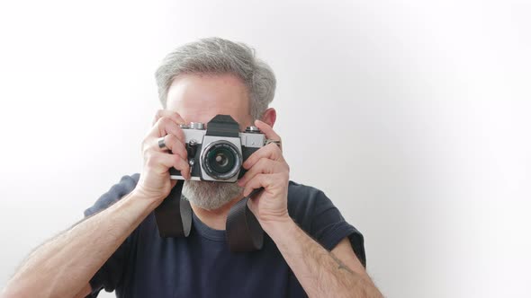 Aged Handsome Photographer Taking a Picture with Film Camera  White Background