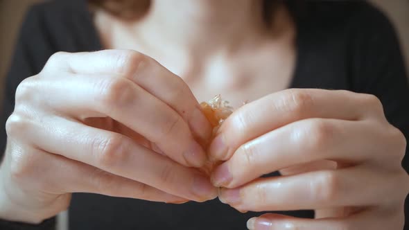 Closeup of Beautiful Young Woman Peels Boiled Shrimp