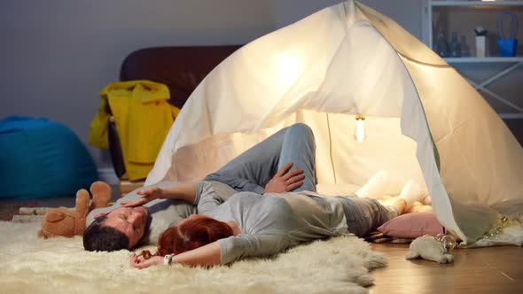 Wide Shot Romantic Relaxed Husband and Wife Lying at Tent in Living Room Talking in Slow Motion