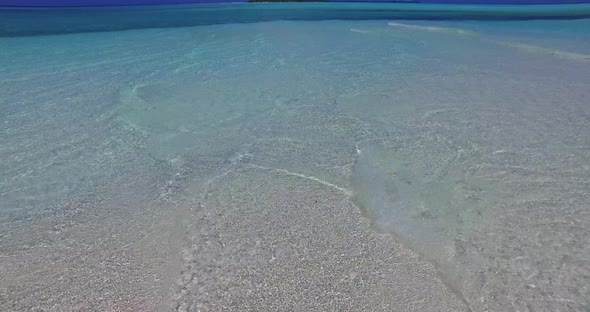 Daytime fly over island view of a paradise sunny white sand beach and aqua turquoise water backgroun