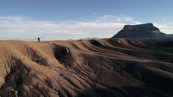 Lone man walking on sand dune on hill in the desert