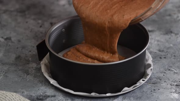 Woman Pouring Chocolate Batter Into a Pan