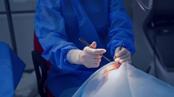 Endoscopic eye surgery. Surgeons holding medical instruments in hands and looking at patient