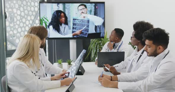 International Team of Doctors Discussing Results of X-ray of Treatment During Video Conference