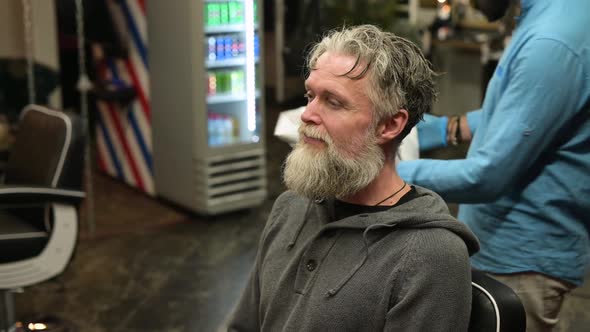 Close-up of a barbershop client getting ready for a hair and beard cut