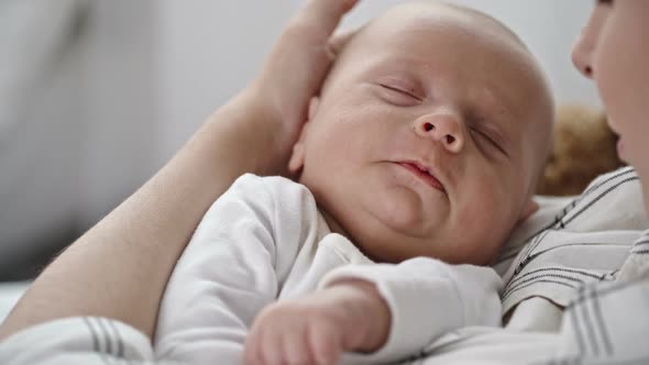 Infant Sleeping in Arms of Mother