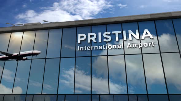 Airplane landing at Pristina Kosovo airport mirrored in terminal