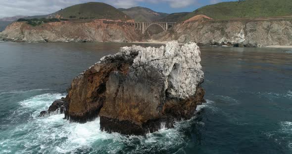 Aerial Drone Stock Video of Bixby Bridge Highway with water and shore below in Big Sur Monterrey Cal