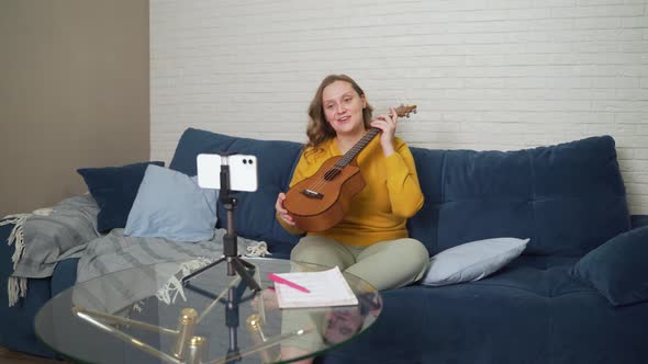 Woman Conducts an Online Lesson and Teaches Students to Play the Ukulele