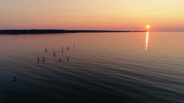 Aerial View of Sup Surfers on Sea at Sunset