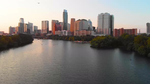 Cinematic shot of austin texas, with people enjoying the lake, and a bird flying majestically across