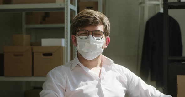 Happy Worker of Storage Sitting and Smiling Employee of Warehouse Wearing Medical Protective Mask