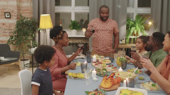 Afro Man Making Toast During Family Dinner / Videohive
