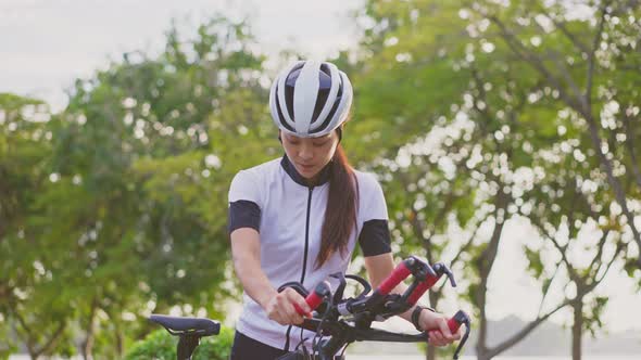 Asian young beautiful woman in sportswear riding bicycle for health in the evening in public park.