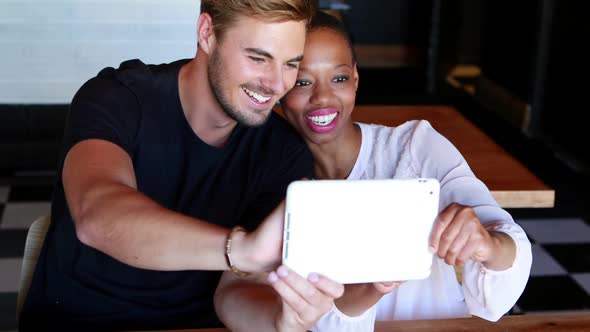 Happy couple taking selfie on digital tablet
