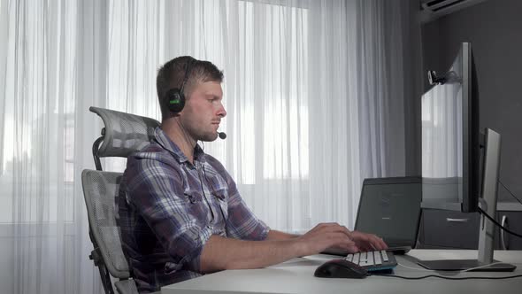 Handsome Customer Support Operator Typing on a Computer