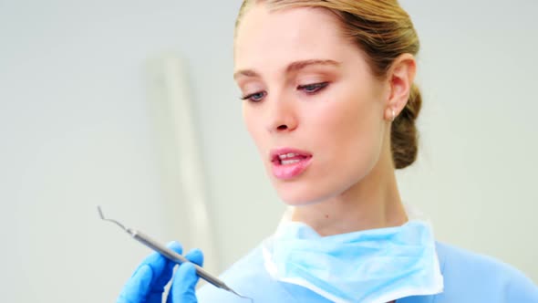 Female nurse looking at dental tools