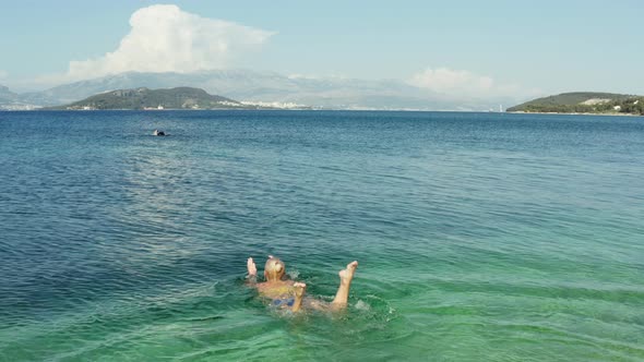 Aerial View of a Woman Diving Into the Ocean