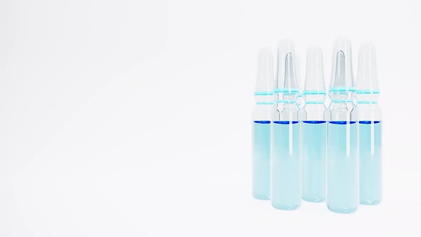 Ampoules with Blue Liquid Rotate on White Background with Shallow Dof