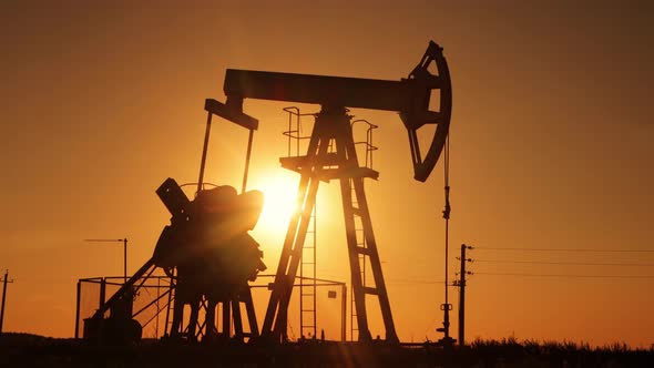 Silhouette of an Oil Pump in the Rays of the Sun