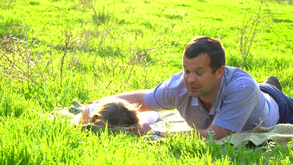 Happy Father and Daughter Resting on the Grass