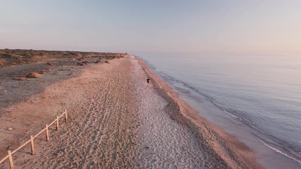 Young runner man training on beautiful sunset at beach