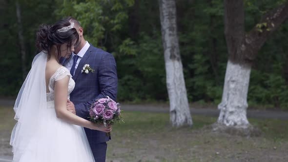 Slow Motion Nice Couple in Wedding Dressing Hugs in Park