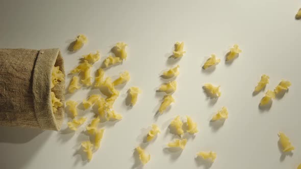 Bag Falls And Pasta Is Poured Out Of It On White Background