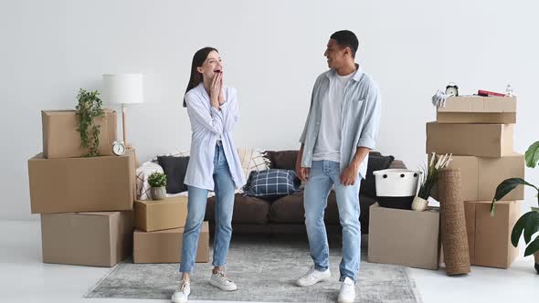 Happy Multiracial Young Couple in Love Looks Their New Home Look Around the Interior with Excited