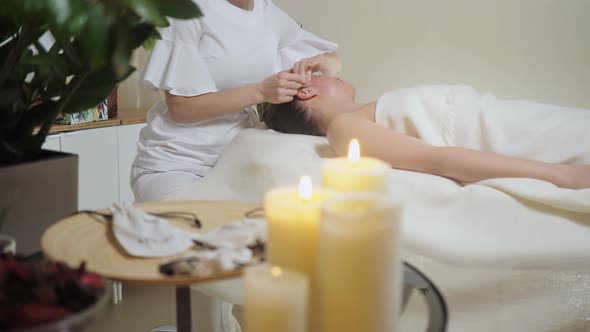 Cute Brunette on a Massage with Gouache Stones of the Temporal Zone