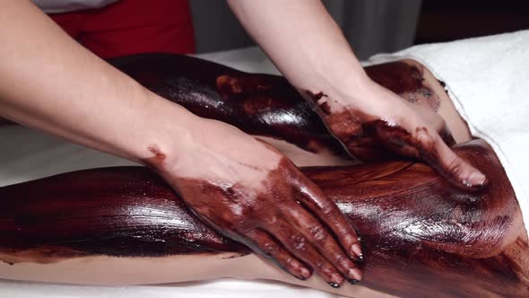 Closeup of Man Massaging Woman Legs Using Mask