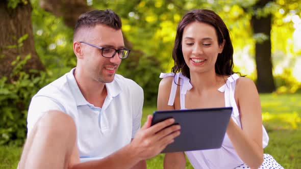 Happy Couple with Tablet Pc at Summer Park