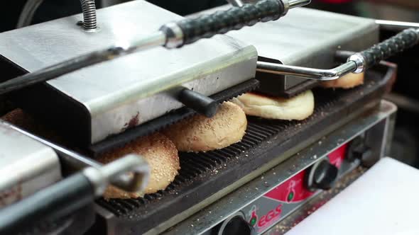 Cook Roasts Burger Buns on the Street Food Festival in Kiev