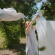 Pretty Woman Hanging Up Clean Wet Clothes On Clothesline in Countryside in Summer Day - VideoHive Item for Sale