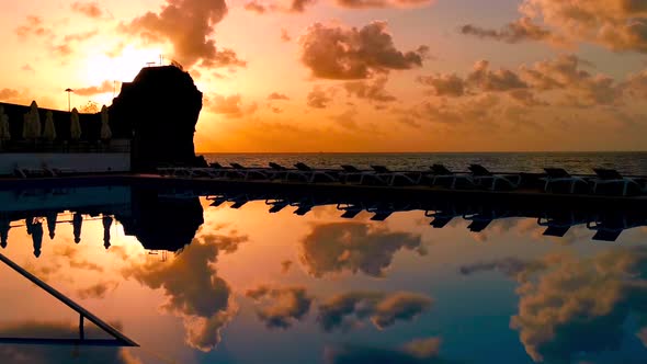 Beautiful sunset reflection in a pool in front of the beach. Relaxing and calm evening atmosphere.