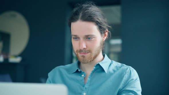 Happy Young Male Office Employee Working on Laptop Computer