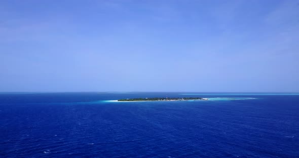 Wide angle birds eye clean view of a paradise sunny white sand beach and blue sea background in vibr