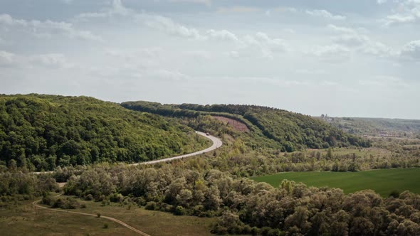 Aerial View of White Truck with Cargo Semi Trailer and Several Cars Moving on Road in the Mountains