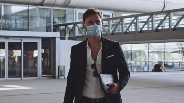 Business Man in Attire Walking Past Entrance Going to Airport Departure Gate