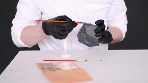 Closeup of Hands in Black Gloves Coloring Silver Pot