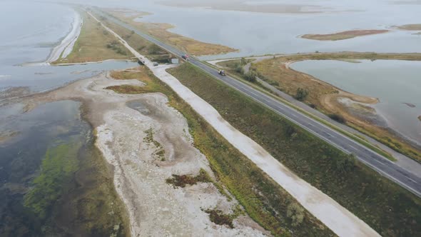 An Aerial View of Trucks on the Road Surrounded By Water